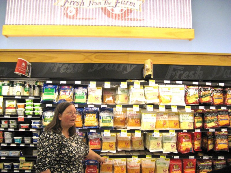 woman standing in front of dairy isle in grocery store
